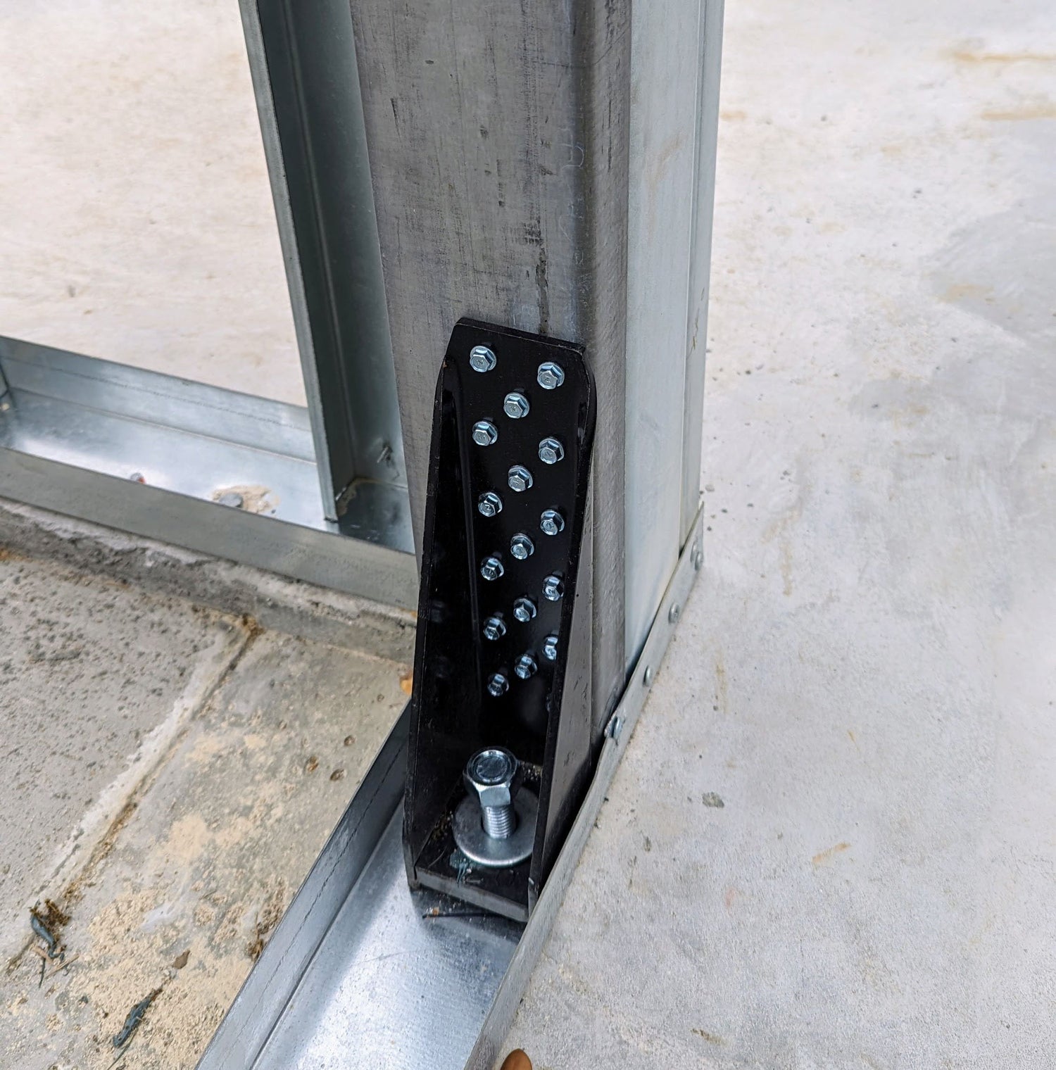 Clark Dietrich Holdown used for securing the steel framing to a concrete slab in commercial steel framing
